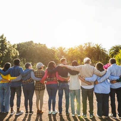 Group of multigenerational people hugging each others - Support, multiracial and diversity concept - Main focus on senior man with white hairs